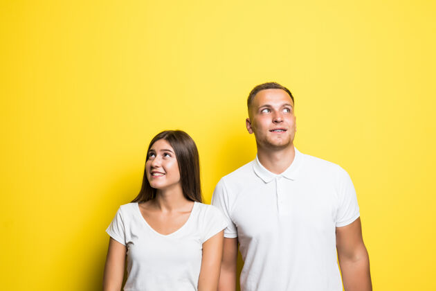 女孩梦见一对被隔离在黄色背景下的年轻夫妇一起穿着白色t恤年轻看在一起
