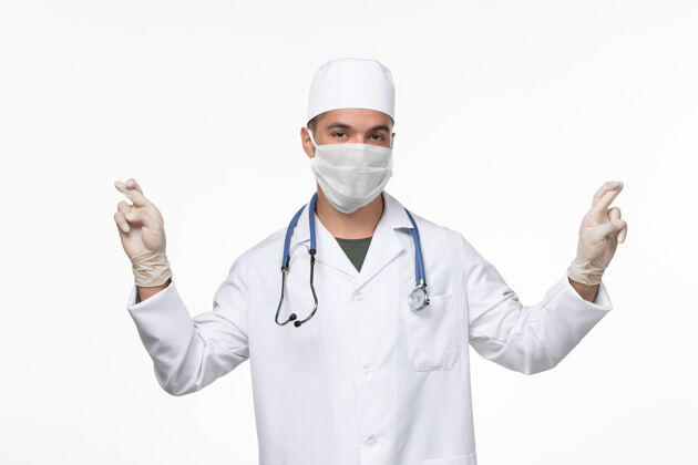 防护正面图：男医生穿着医疗服 戴着防病毒口罩 白色地板上有病毒-病毒-疾病大流行疾病穿戴病毒