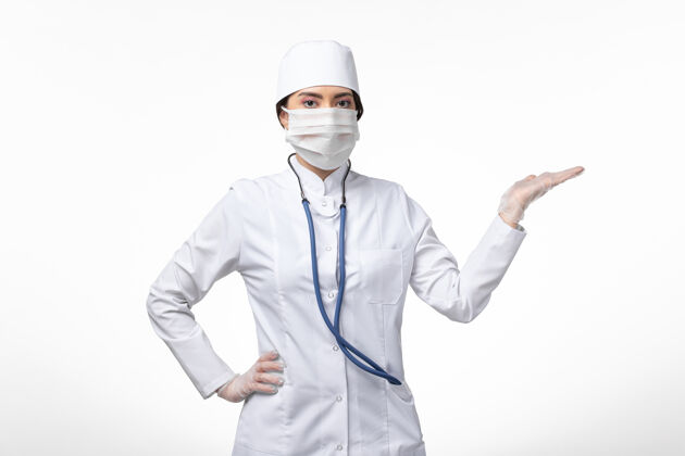 到期正面图：女医生穿着白色无菌医疗服 带着口罩 因为柯维德-白桌子上的疾病柯维德-大流行疾病桌子肖像女性