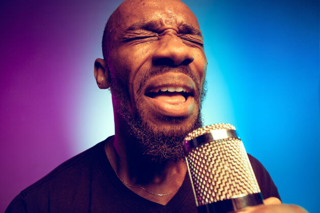 声音年轻的非洲裔美国爵士乐音乐家在渐变的紫蓝色上唱歌成人演奏爵士乐