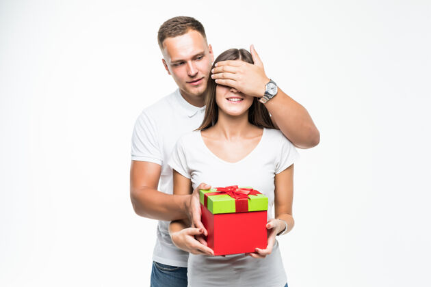 生活年轻貌美的情侣给他的女士一个白色的礼物盒惊喜给予祝贺礼物