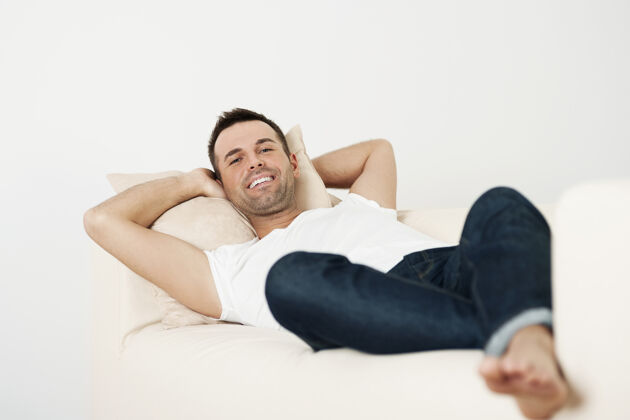 舒适快乐的男人在家的沙发上放松沙发胡茬穿着得体