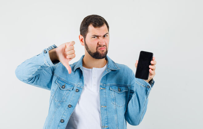 而复古风格的男人展示拇指向下 而显示手机在夹克衫 t恤衫和看起来不满意前视图向下电话优雅