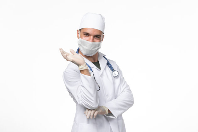 微笑正面图男医生穿着医疗服 戴着口罩 因柯维德-微笑白墙柯维德-病毒药大流行疾病视图外套冠状病毒