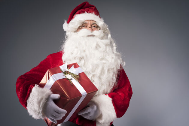 十二月拿着礼品盒的圣诞老人服装站立愿望