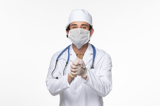 外套正面图：男医生穿着医疗服 戴着无菌口罩 以防白墙病毒冠状病毒大流行时与冠状病毒握手疾病病毒实验室外套