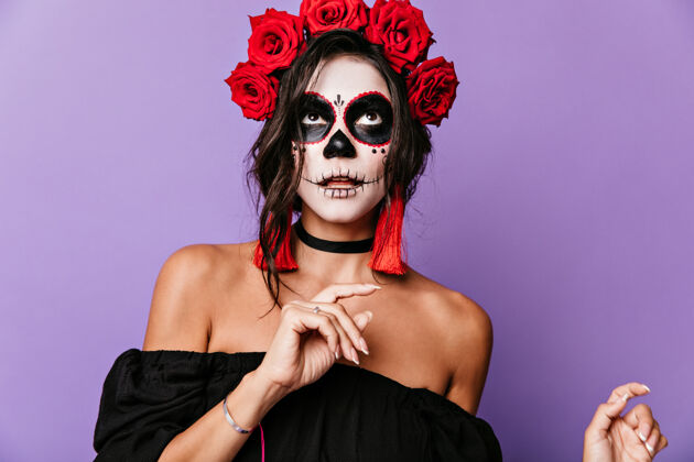 魔鬼紫丁香墙上晒得黝黑的拉丁女人在思考一头卷曲的黑发 戴着玫瑰 脸上戴着骷髅面具的女孩装饰脸庆典