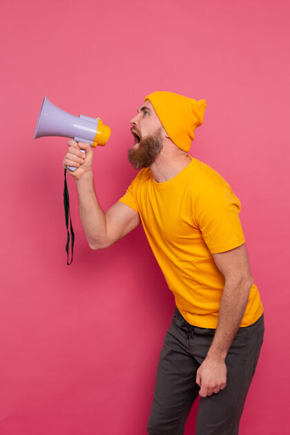 音频注意 愤怒的欧洲男人在粉红色背景上用扩音器喊叫声音销售噪音