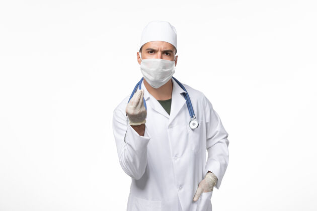 大流行正面图：男医生穿着医疗服 戴着防毒面具 白色办公桌上的科维氏病大流行病毒男性套装视图