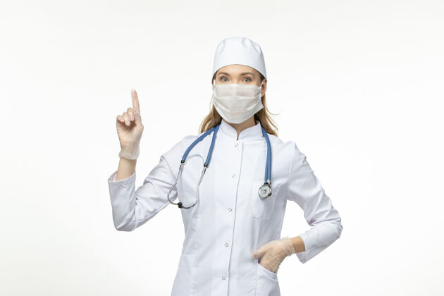 医疗正面图女医生穿着医疗服戴口罩因冠状病毒对浅白色地板病冠状病毒-大流行病毒病女性专业医生