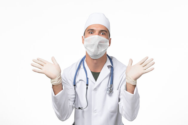 专业正面图男医生穿着医疗服 戴着口罩 因为白色地板上有病毒-病毒药大流行疾病地板医疗处方药