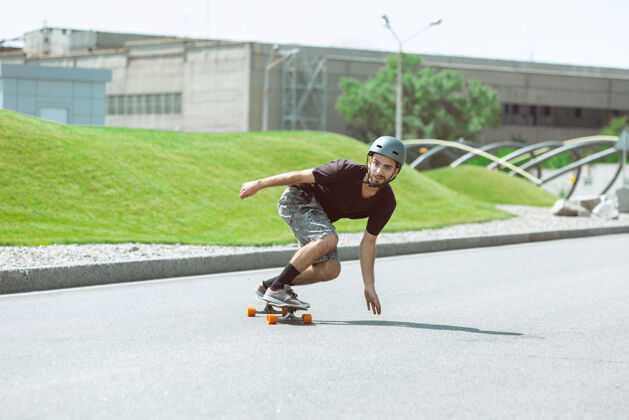游戏在阳光明媚的日子里 滑板手在城市的街道上玩花样车轮速度极限