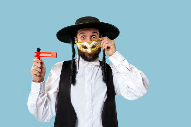 犹太人一个年轻的东正教犹太男子与木制棘轮在普瑞姆节画像面具神圣犹太教