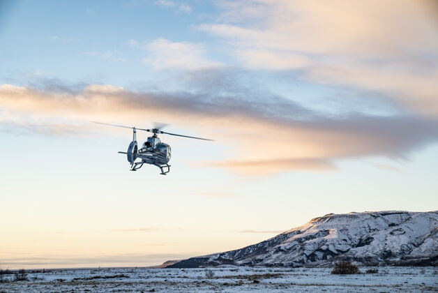 高山直升机飞过白雪覆盖的苔原冰岛机器飞行