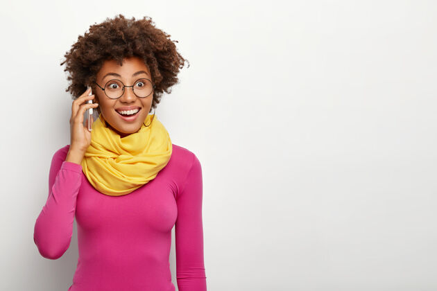 复制空间黑人发型的快乐黑皮肤女人的肖像 戴着眼镜 圆领衫 脖子上围着黄色围巾 表情愉快 模特们在白色的工作室墙上围巾非洲非洲