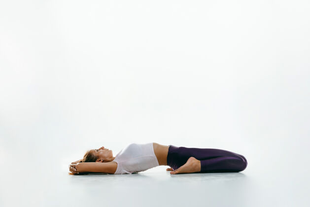 训练在运动空间练习瑜伽的年轻女性身体灵活能量