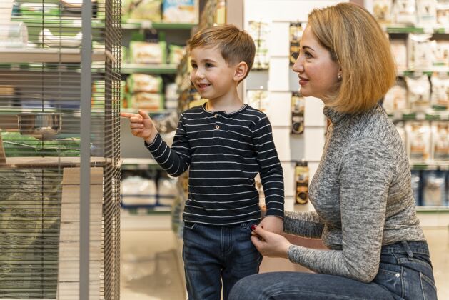 家庭小男孩正在检查宠物店的产品动物商品客户