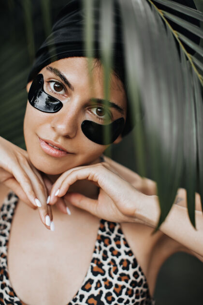 年轻人棕榈树下戴着眼罩的可爱女人的正面图美丽的女模特在热带背景下摆姿势感性森林户外