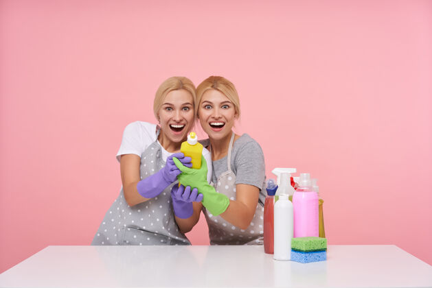 洗涤剂年轻的金发可爱的主妇们戴着橡胶手套准备春季大扫除金发妹妹家庭