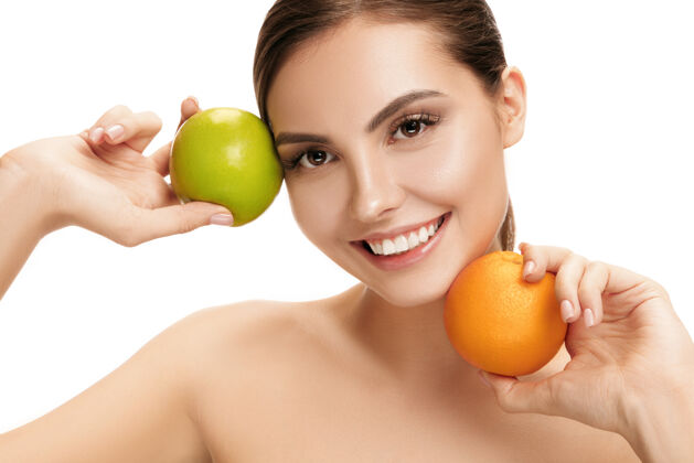 快乐美丽的白种人微笑的女人的肖像被隔离在白色的工作室墙上 绿色的苹果和橙色的水果美丽 护理 皮肤 治疗 健康 水疗 化妆品和广告概念清洁饮食保健