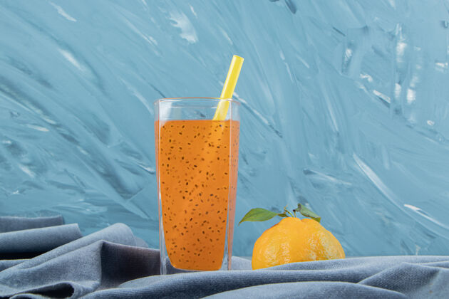 杯子加工果汁和柠檬 在毛巾上 在蓝色背景上高品质的照片果汁牙粉柠檬