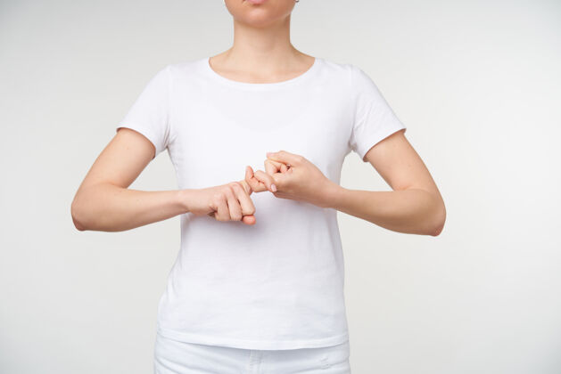 女性摄影棚拍摄的年轻女士举起双手 交叉食指 同时使用聋哑语言 被隔离在白色背景下穿着休闲服站立交流手