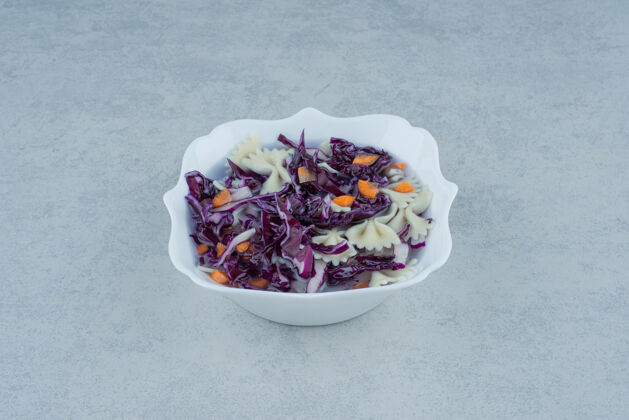 卷心菜白色盘子上放着通心粉和卷心菜高质量的照片意大利面白的盘子
