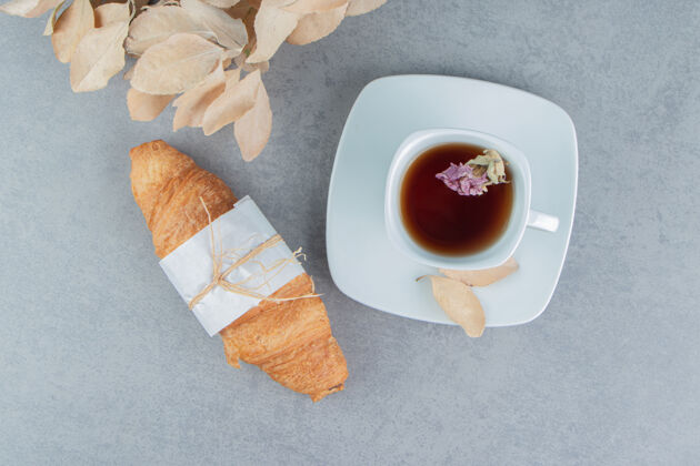 甜食茶 羊角面包和叶子在大理石背景上高质量的照片杯子配料巧克力