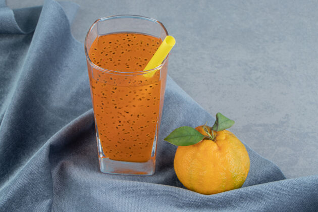 杯子加工果汁和橘子 在毛巾上 在蓝色背景上高质量的照片配料果汁美味