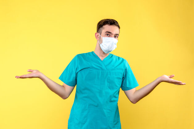 冠状病毒黄墙上戴着无菌口罩的男医生的正视图健康护目镜正面