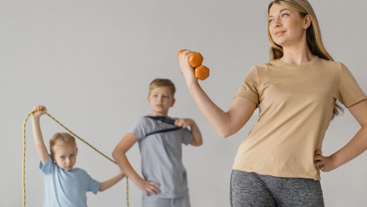 室内运动中枪女人和孩子们在锻炼室内运动健身教练哑铃