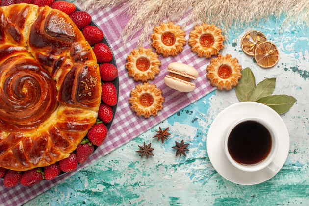 营养品俯瞰美味的草莓派和一杯茶在蓝色的表面咖啡晚餐食物