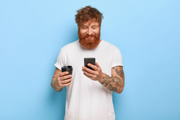 胡须拍到了一个满脸笑容的红发男人拿着手机摆姿势快乐男性笑