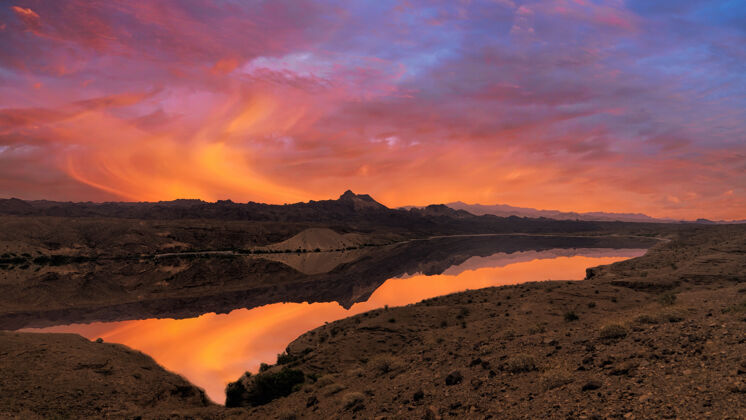 自然日落时草地上的湖黎明红天风景