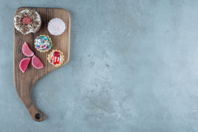 口感在大理石背景的木板上捆绑各种各样的糕点和marmelades高质量的照片糖果美味美味