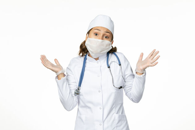 护士正面图年轻女医生戴着无菌口罩和防护手套 白色表面有冠状病毒面罩疾病听诊器