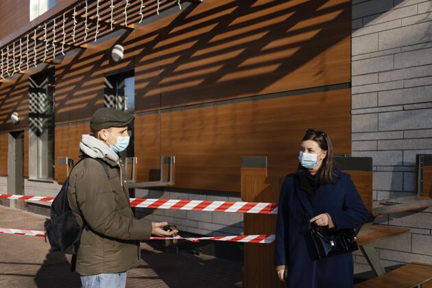 社会距离街上戴着面具的男人和女人外科面具男人措施