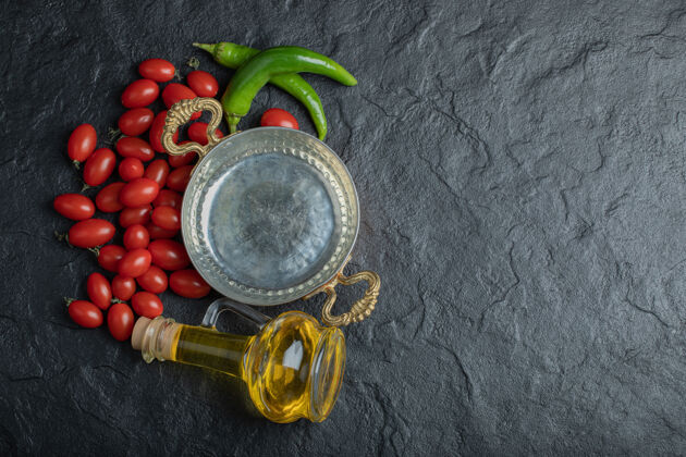 瓶子樱桃番茄 青椒炒锅和一瓶油的照片高品质的照片油胡椒配料