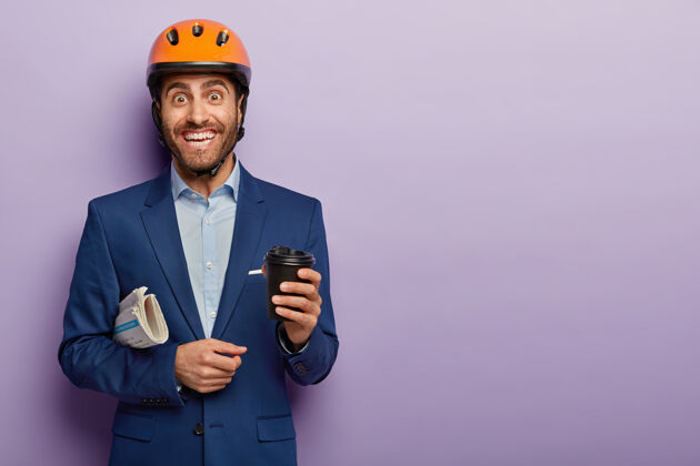 外卖快乐快乐的男建筑工人下班后喝咖啡休息 戴着安全帽和优雅的西装 积极微笑紫色男人未刮胡子