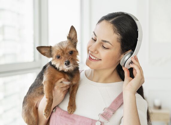 宠物带着耳机和狗的特写女孩女孩床狗