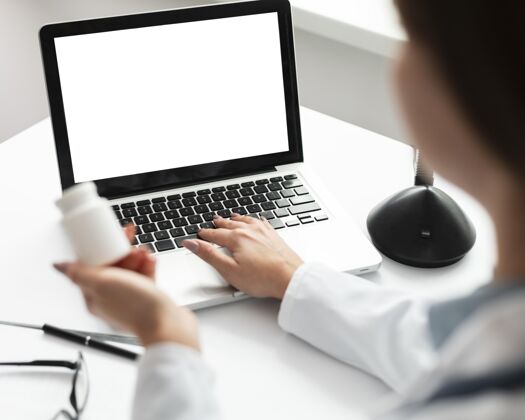 医生女医生在做一台模拟笔记本电脑模型药房医学