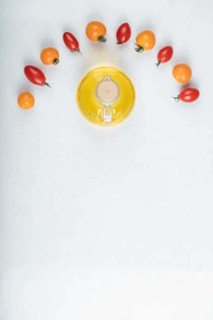 有机红色和黄色的西红柿在白色的背景上闪烁 还有一瓶油高质量的照片农业光泽农业