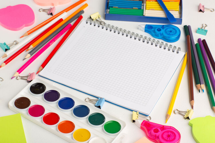 学校半顶视图彩色铅笔与油漆和贴纸上的白色书桌艺术画彩色油漆绘画信封书桌