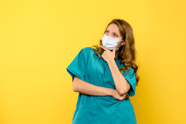 病毒正面图黄色地板上戴着面罩的女医生-病毒大流行医疗面具防护罩