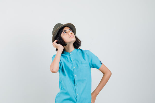 积极穿着蓝衬衫 戴着帽子 望着天空的年轻女士人看休闲