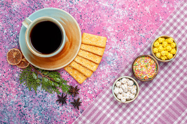 早晨在粉红色的桌子上可以看到一杯茶 里面放着饼干和糖果脆饼干糖果
