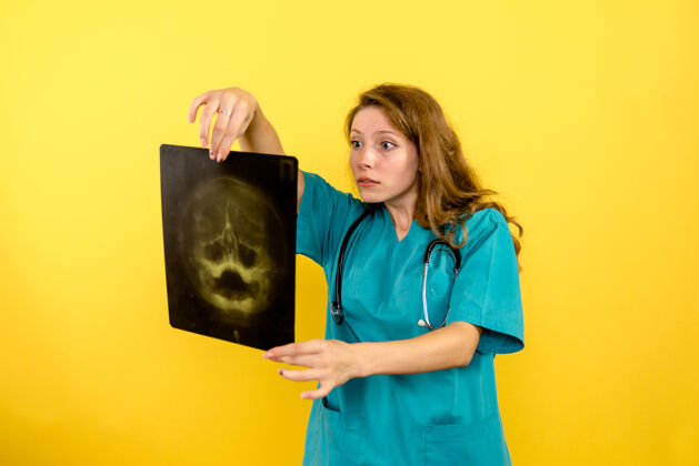 漂亮正面图黄色空间女医生拿着x光片健康成人微笑
