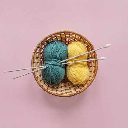 线毛线和编织针放在篮子里针织针羊毛顶视图