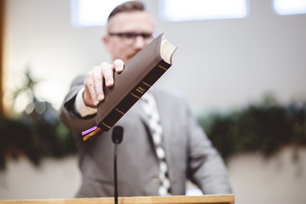 男性一个男人站着 手里拿着一本书的选择性聚焦镜头教科书人类胡须