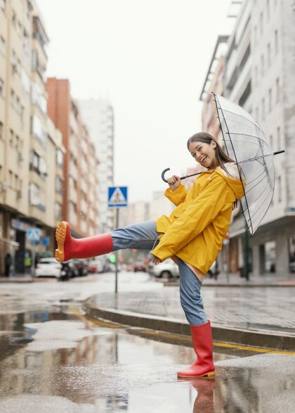 长相带伞的女人站在雨中的正前方女性模特休闲